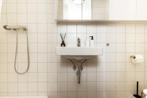 a white bathroom with a sink and a shower at Air Apartment 211 in Vilnius