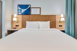 タイラーにあるStaybridge Suites Tyler University Area, an IHG Hotelのホテルルーム内の大きな白いベッド