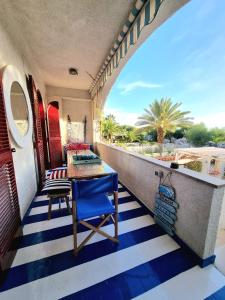 une terrasse couverte avec une table bleue et une chaise bleue dans l'établissement VISTA MARE Su tre piani con giardino, à Falerna