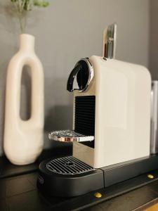 a white toaster sitting on a counter next to a vase at Klassen Stay - Exklusives Apartment am HBF - Küche, Netflix, Kingsizebett in Koblenz