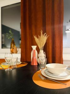a table with plates and bowls and glasses on it at Klassen Stay - Exklusives Apartment am HBF - Küche, Netflix, Kingsizebett in Koblenz