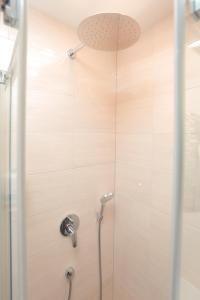 La salle de bains est pourvue d'une douche avec une porte en verre. dans l'établissement Branša, à Telšiai
