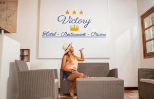 a woman sitting on a chair in a waiting room at Victory Hotel & Restaurant Tulear in Toliara