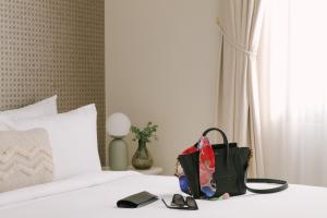a bag and a pair of shoes sitting on a bed at Sonder Salute Palace in Venice