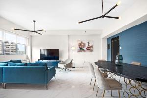 Don Rafa Boutique Hotel & Residences في سان خوان: غرفة معيشة مع أريكة زرقاء وطاولة