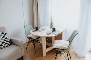 einen kleinen weißen Tisch mit zwei Tassen und zwei Stühlen in der Unterkunft Soul Apartments in Izola