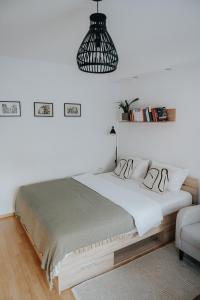 ein Schlafzimmer mit einem Bett und einer Hängeleuchte in der Unterkunft Soul Apartments in Izola