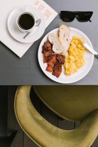 een tafel met een bord ontbijtproducten en een kopje koffie bij Salute Palace powered by Sonder in Venetië