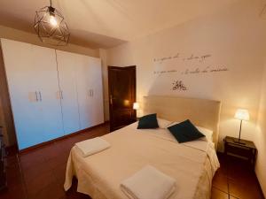 1 dormitorio con 1 cama blanca y 2 almohadas en Il Casale di B, en Acilia