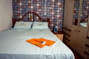ein Bett mit zwei orangenen Handtüchern darüber in der Unterkunft Caminhos de Caravaggio - Hostel Parada dos Caminhantes in Nova Palmira