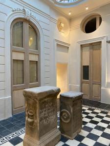 a building with two stone benches on a checkered floor at Hotel Atia in Guadalajara