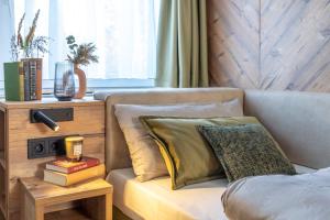 a bedroom with a couch and a table with books at Feinheit Hotel & Restaurant in Halsenbach