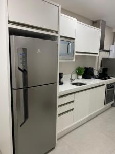 a stainless steel refrigerator in a kitchen with white cabinets at Encantos dos Mares - Apartamento 5 - Balneário Camboriú in Balneário Camboriú