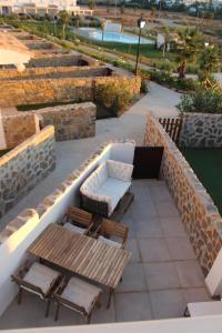 a patio with a couch and a table and chairs at CASA ROMPEOLAS Atlanterra in Zahara de los Atunes