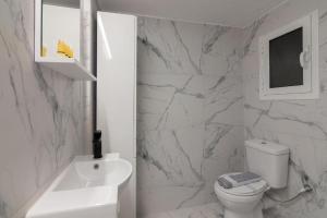 a bathroom with a white toilet and a sink at Fully renovated 1 bedroom condo in Athens +9 photos