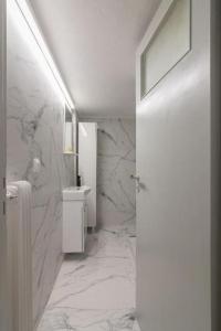 a white bathroom with a sink and a toilet at Fully renovated 1 bedroom condo in Athens