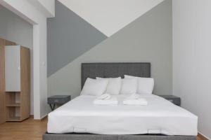 a bedroom with a large white bed with two night stands at Fully renovated 1 bedroom condo in Athens