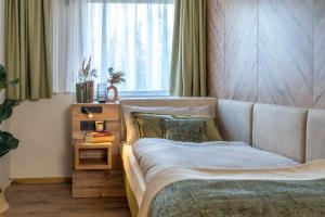 a bed in a bedroom with a large window at Feinheit Hotel & Restaurant in Halsenbach