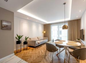 salon z kanapą, stołem i krzesłami w obiekcie Luksus w centrum nad Odrą we Wrocławiu