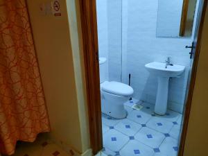 a bathroom with a toilet and a sink at Travelers staycation - 15 Mins to Westlands in Kikuyu