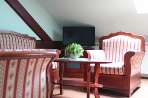 a living room with two chairs and a table and a tv at Siesta in Kikinda