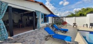un patio con sillas azules y una piscina en Hospedaje Campestre El Deseo, en El Caimo