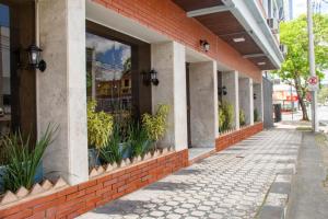a red brick building with plants in the windows at HOTEL DOMHOF in Blumenau