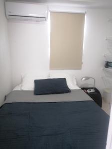 1 dormitorio con 1 cama con manta azul en Hermoso Apartaestudio, privado, acogedor, super aseado, excelente ubicación!, en Cartagena de Indias