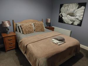 a bedroom with a bed with two lamps and a flower painting on the wall at Jack's Place Beautiful 3-Bed House Donegal in Stranorlar