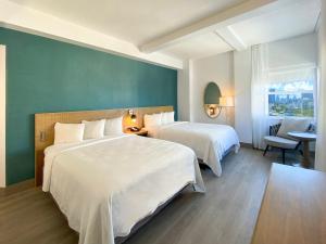 A bed or beds in a room at Marseilles Beachfront Hotel