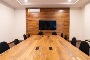 Sala de conferencias con mesa de madera y TV de pantalla plana en Armony studio in Aldea Zama Giada Towers 205, en Tulum