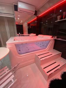 a pink bath tub in a room with red lights at Samm B&B Porta San Gennaro in Naples