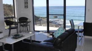 a living room with a couch and a view of the ocean at Bluefish in Yamba