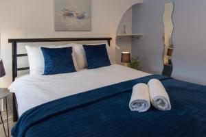 Un dormitorio con una cama azul y blanca con toallas. en 147 The Residence, en Belfast