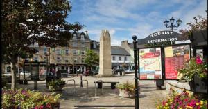 a town square with a street sign and flowers at Jack's Place Beautiful 3-Bed House Donegal in Stranorlar