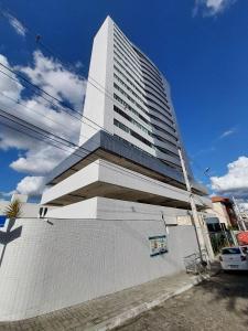 a tall white building on the side of a street at Apartamento Encanto próximo ao Pátio do forró in Caruaru