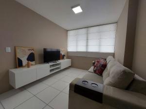 uma sala de estar com um sofá e uma televisão em Apartamento Encanto próximo ao Pátio do forró em Caruaru