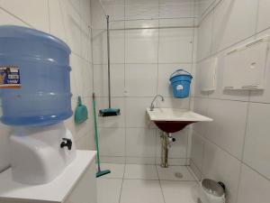 a bathroom with a toilet and a sink with a blue bucket at Apartamento Encanto próximo ao Pátio do forró in Caruaru
