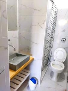 a white bathroom with a sink and a toilet at Hotel Ruta 66 Oficial in Paso de los Libres