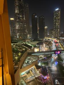 杜拜的住宿－Address Dubai Mall Residences New name EMAAR Residences Fashion Avenue 1 bedroom 34 floor，享有夜间城市景观和建筑