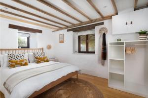 um quarto com uma cama grande e paredes brancas em Cosy cottage, walk to Porthcurno beach, Pedn Vouder, Minack & PK Museum em Penzance