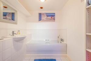 a white bathroom with a tub and a sink at Location, Location, Location with King Size Bed in Kent