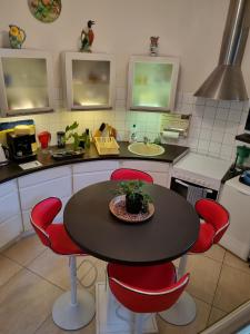 eine Küche mit einem Tisch und roten Stühlen in der Unterkunft Moulin Vieux in Saint-Palais-sur-Mer
