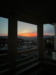 - une vue sur le coucher du soleil depuis la fenêtre dans l'établissement Komplette Wohnung 40m2 mit schöner Terrasse Niedernhausen, à Niedernhausen