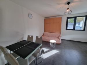 ein Esszimmer mit einem Tisch und einem Bett in der Unterkunft Studio Blackbird in Grimisuat