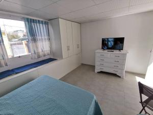 1 dormitorio con cama y vestidor con TV en Acogedor departamento, en Santa Rosa