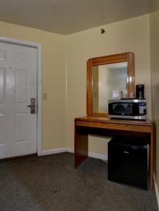 Habitación con encimera, microondas y espejo. en Brookside Inn & Cottages en Saco