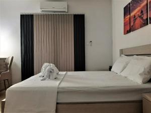 a bedroom with a white bed with an elephant toy on it at Royal Lovely Apartment! in Paphos City