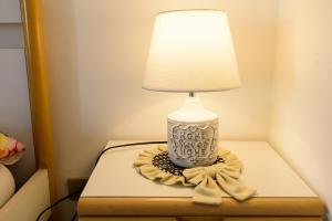 a lamp on a table with a bow around it at Casa vacanze SICILIA in Barcellona-Pozzo di Gotto