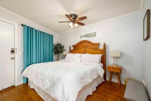 - une chambre avec un grand lit et un ventilateur de plafond dans l'établissement Oceanfront Hilton Head Island Condo with Pool!, à Île de Hilton-Head